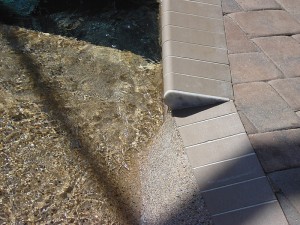 Coping with Beach Entry into pool with pebble finish