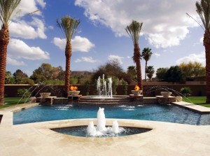 custom in-ground pool with multiple fountains, deck sprayers and flaming urns